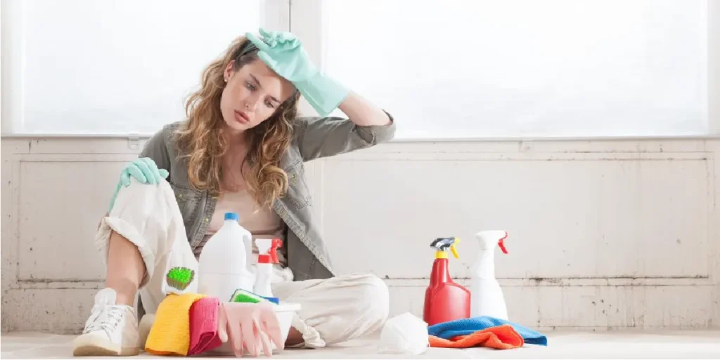 Mujer cansada tras intentar limpiar humedades sin éxito con productos convencionales mejorar salud hogar