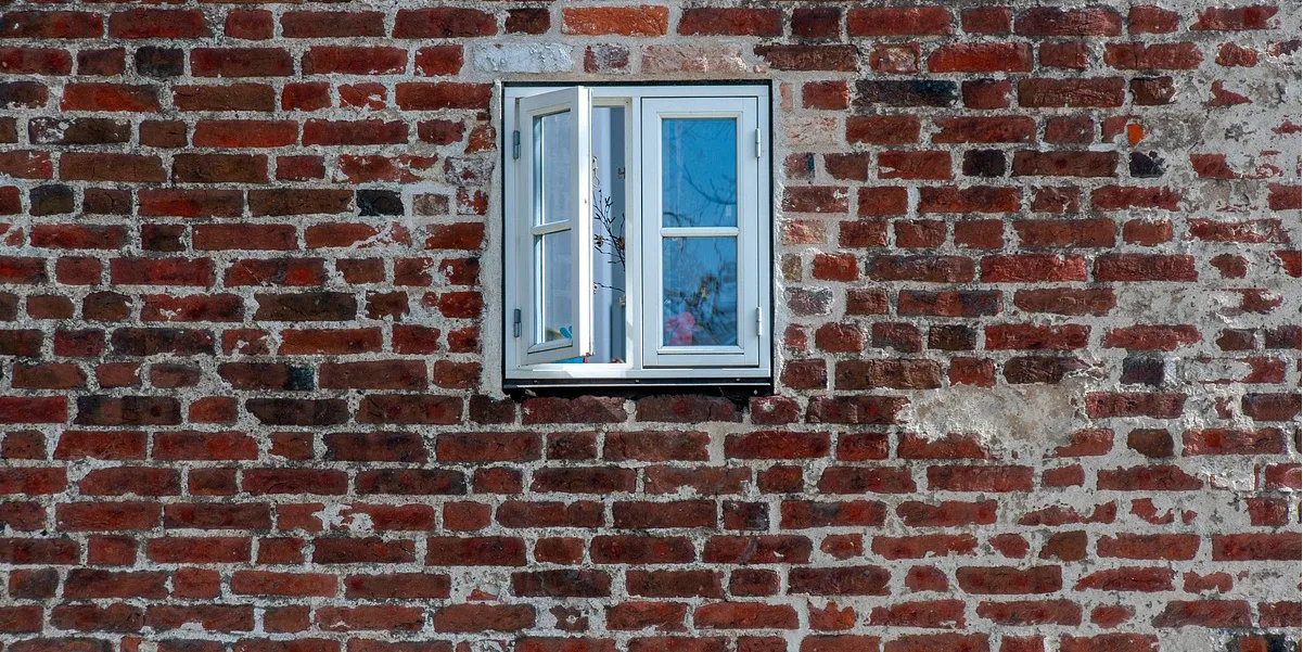 Muro antiguo con humedad y ventana sin aislamiento, ejemplo de baja eficiencia energética en viviendas antiguas 2030